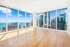 Stunning apartment with panoramic floor-to-ceiling windows, showcasing breathtaking city and lake views, and elegant hardwood flooring.