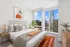Elegant bedroom with modern decor and panoramic city views through floor-to-ceiling windows.