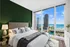 Luxurious bedroom with stunning floor-to-ceiling windows showcasing a breathtaking city skyline and waterfront view.