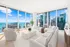 Luxurious open-concept living room with panoramic city and ocean views, showcasing modern furniture and natural light.
