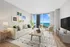Contemporary living room with chic decor, showcasing a stunning city and lake view through expansive windows.