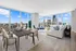 Luxurious open-concept living and dining area with breathtaking city skyline views, floor-to-ceiling windows, and stylish modern decor.