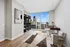 Chic home office with elegant desk and chair setup, featuring a stunning skyline view from floor-to-ceiling windows.