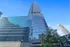 Breathtaking modern skyscraper with sleek glass facade in a vibrant urban setting under a clear blue sky.