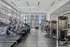 State-of-the-art gym featuring modern cardio and strength training equipment with a stunning city view through large windows.