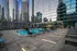 Luxurious rooftop oasis featuring a sparkling pool, chic lounge chairs, and stunning cityscape views.