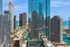 Breathtaking cityscape view featuring modern high-rise buildings with stunning glass facades, nestled next to serene waterfront and vibrant urban landscape.