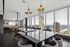 Luxurious open-concept living area with a sleek modern design, featuring expansive floor-to-ceiling windows offering breathtaking city and waterfront views.