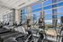 Modern fitness center with state-of-the-art cardio equipment and breathtaking city skyline views.