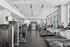 Modern fitness center with state-of-the-art machines, large windows offering an abundance of natural light, and a sleek design for an energizing workout environment.