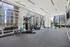 Modern fitness center with state-of-the-art equipment and stunning cityscape views from large windows.