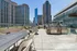 Spacious urban rooftop terrace with modern seating and barbecue grills, offering stunning city skyline views.