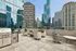 Chic urban rooftop terrace with modern seating, grill, and panoramic city skyline views.