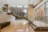Elegant modern lobby with glass accents, sleek staircase, and panoramic city views.
