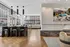 Sophisticated open-concept living area with floor-to-ceiling windows, modern kitchen island, and cozy fireplace, offering stunning city views.