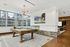 Luxurious apartment lounge with a billiards table, stylish lighting, and large windows showcasing a stunning city view.