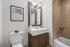 Modern bathroom featuring elegant wooden vanity, stylish mirror, and a sleek bathtub with contemporary fixtures.