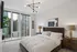 Modern bedroom with chic design, featuring large windows showcasing stunning cityscape views and elegant decor.