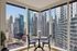 Stunning urban view from modern apartment dining area with floor-to-ceiling windows and chic round table.