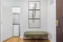 Modern entryway featuring a sleek in-unit washer-dryer, elegant wall art, and a stylish olive green bench.