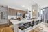 Sleek modern kitchen with high-end appliances, stylish pendant lighting, and a spacious island with cityscape views.