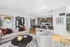 Elegant open-concept living space with modern sofa, stylish decor, and bright kitchen with sleek bar seating.