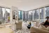 Elegant living room with modern decor, featuring floor-to-ceiling windows showcasing stunning city skyline views.