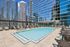 Luxurious rooftop pool surrounded by sleek modern skyscrapers, offering a serene urban oasis with stunning city views.