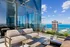 Chic urban balcony with stylish seating overlooking stunning city skyline and expansive ocean views.