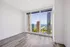 Luxurious apartment room with elegant hardwood flooring and spectacular floor-to-ceiling windows offering breathtaking city and lake views.