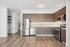 Modern kitchen with sleek stainless steel appliances, elegant wooden cabinetry, and sophisticated laminate flooring, offering a seamless blend of contemporary style and functionality.