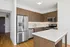 Modern kitchen with sleek stainless steel appliances, elegant wood cabinetry, and a spacious white countertop island.