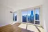 Bright, spacious city apartment with floor-to-ceiling windows offering breathtaking skyline views and elegant wooden flooring.