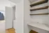 Modern apartment with built-in laundry and sleek shelving, featuring natural light flooding through large windows.