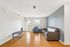 Bright and inviting living room with modern furnishings, featuring a comfortable leather sofa and a large window allowing natural light to flood the space.