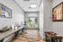 Bright home office space with large window, modern desk setup, and stylish wood flooring.