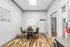 Elegant business center with modern accents, featuring a stylish round meeting table, sleek chairs, and natural light through French doors.