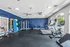Modern fitness center with state-of-the-art gym equipment, including treadmills, weight benches, and vibrant exercise balls, set against stylish blue walls.
