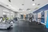 Well-equipped fitness center featuring treadmills, stationary bikes, weight machines, and ample natural light for an invigorating workout.