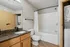 Modern bathroom with elegant granite countertop, sleek wood cabinetry, and in-unit washer-dryer.