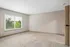 Bright and spacious bedroom featuring large windows with a serene view, perfect for natural light enthusiasts.