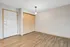 Inviting entryway with sleek hardwood floors and ample closet space, highlighted by modern lighting.