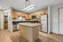 Modern kitchen with sleek granite island, stainless steel appliances, and warm wood cabinetry, perfect for culinary creativity.