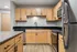 Modern kitchen with sleek stainless steel appliances, elegant wooden cabinetry, and granite countertops.