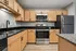 Modern kitchen with sleek stainless steel appliances, elegant granite countertops, and stylish wood cabinetry.