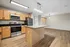 Modern kitchen with sleek stainless steel appliances, elegant wooden cabinetry, and a spacious granite island, offering a warm and inviting open-concept living space.