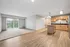 Bright and spacious open-plan apartment with elegant hardwood floors, modern kitchen with wooden cabinetry, and a large window for natural light.