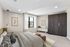 Modern bedroom with cozy bedding, elegant lighting, and a large window for natural light, complemented by a sleek wardrobe and stylish decor.