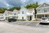 Charming modern homes with pristine white façades, surrounded by lush greenery and ample parking spaces.