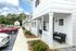 Charming apartment exterior with cozy porch seating, modern design, and lush green surroundings, showcasing an inviting neighborhood atmosphere.